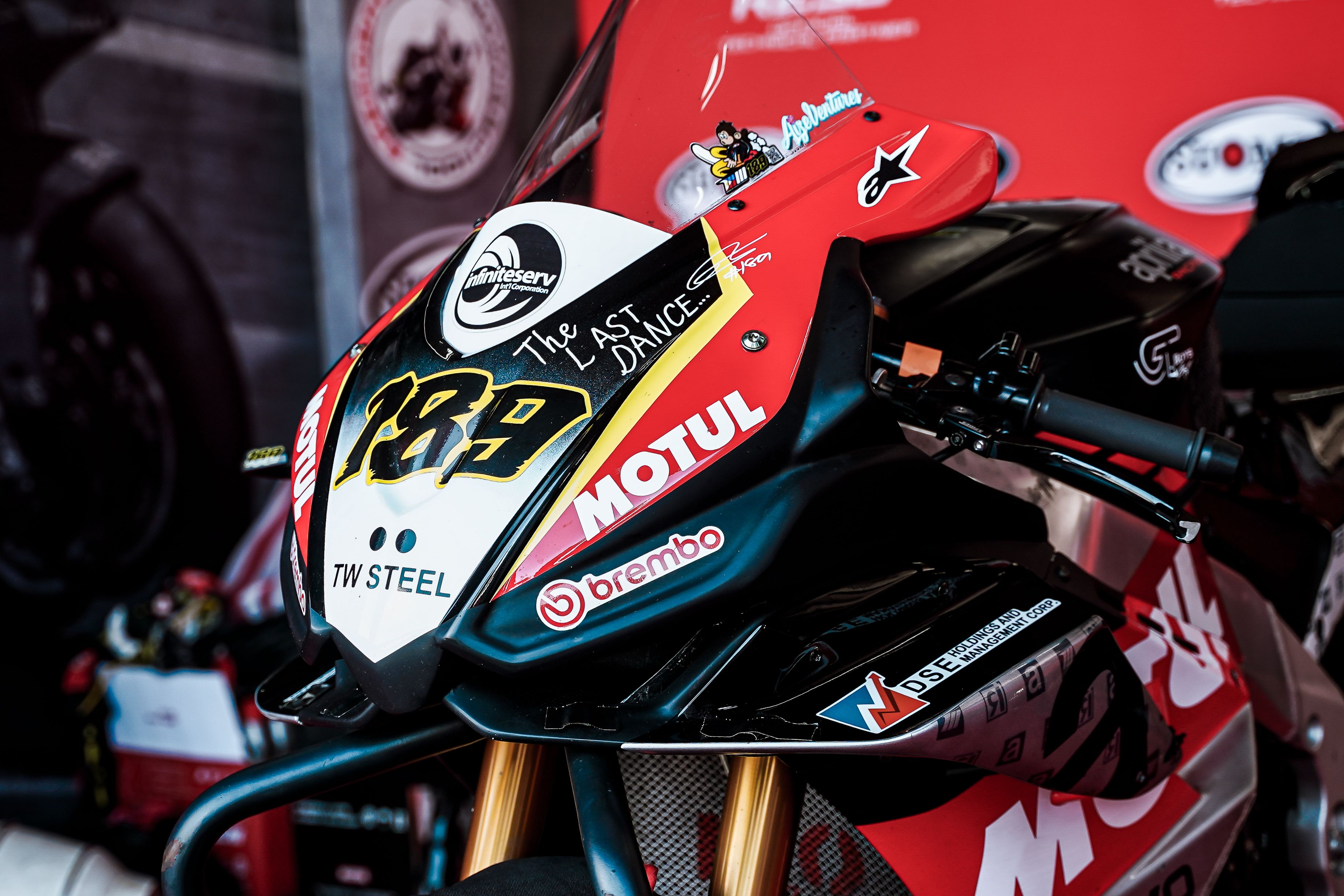 Yellow race motorcycle with number graphics speeding on track