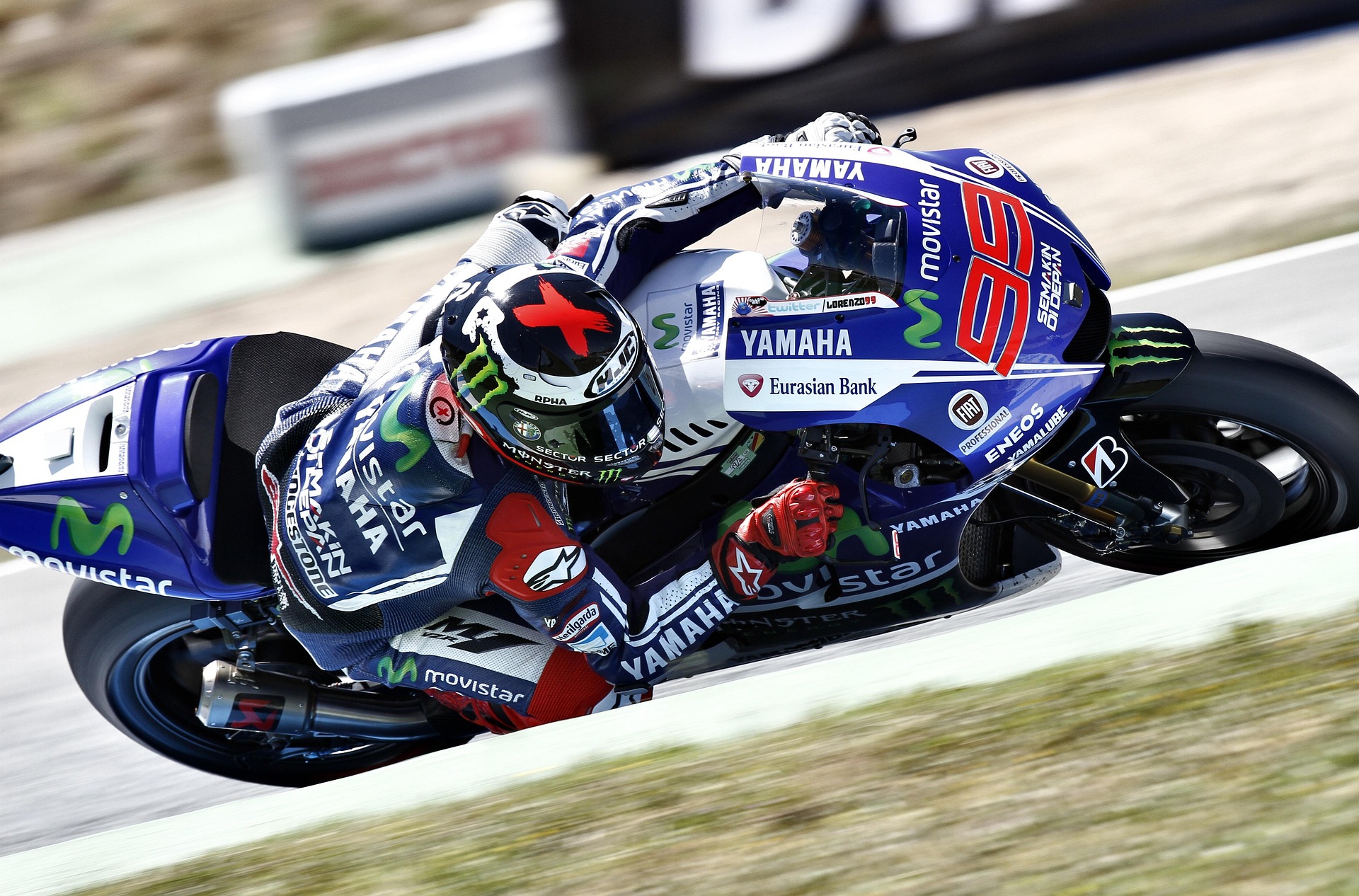 Race motorcycles with sponsor decals speeding around a track
