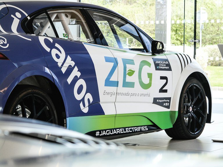 Contingency sponsor decals lined up on a race car quarter panel in a garage
