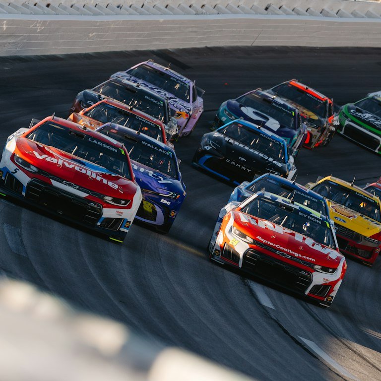 NASCAR-style stock car livery graphics racing on track in Daytona Beach