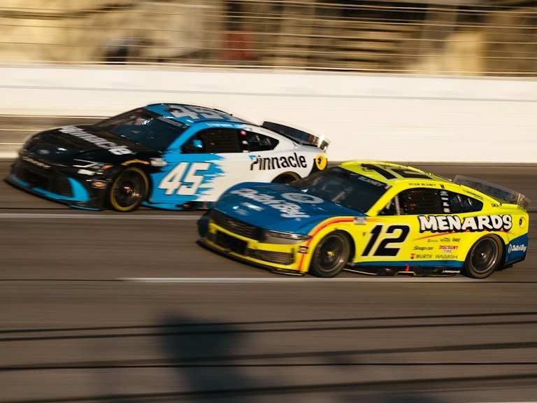Two race cars with motorsports wraps competing on track